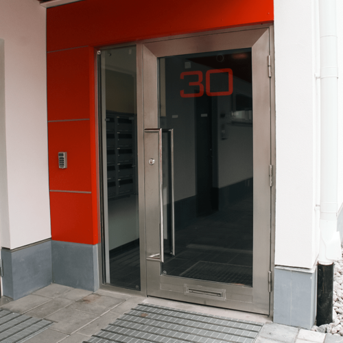 Lägenhetshus ståldörr vid entré. Stålpartier för fastighet.